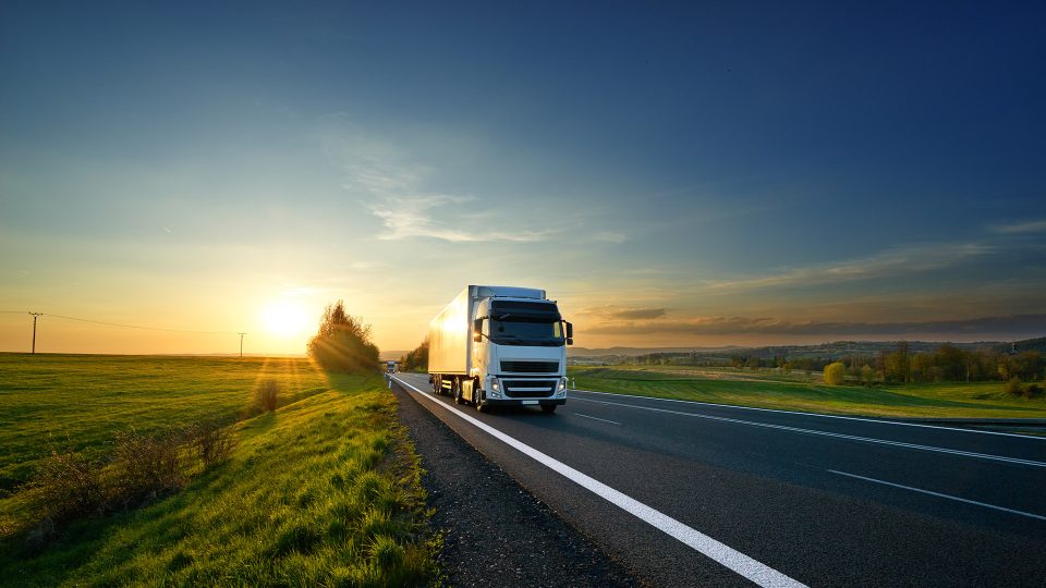 Vit lastbil på väg i solnedgång